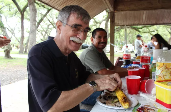 Brad Ginter (left) and Andres Mendoza (right) share a meal on May 28, 2018 at an alumni and friends picnic hosted by MCC's East Coast regional office in Miami, Florida.