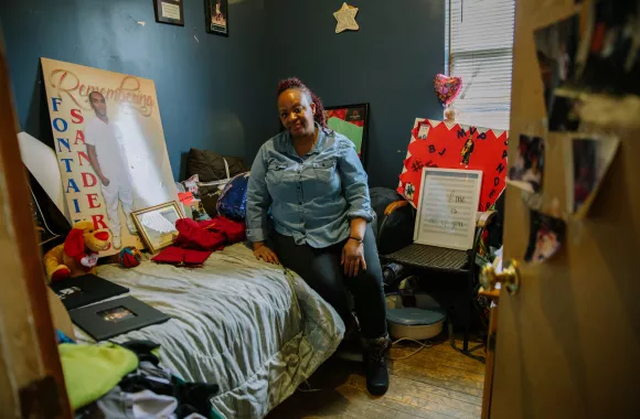 A woman sits on a twin bed