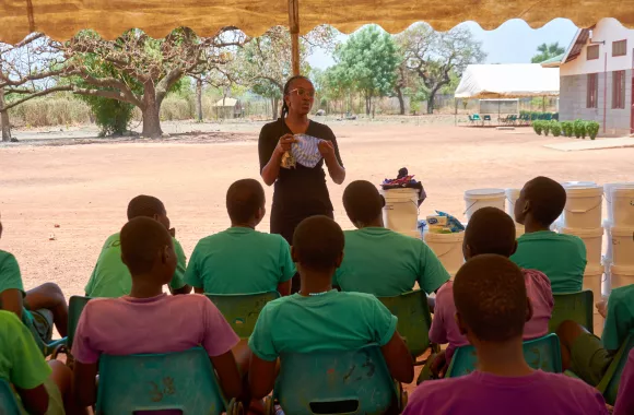 A woman teaching a group of girls about dignity kits