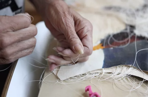 Artist Val Vint's mature hands manipulate natural materials.