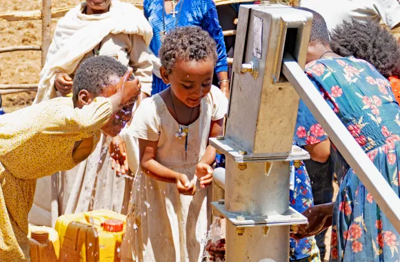 Group of children at a well.