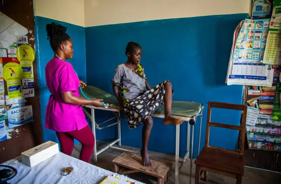 Nurse Marcelline Kuwana examines Angele Kingenzi at Kanzombi Secondary Hospital because Angele had a fever for two days.