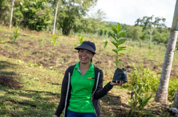 Etel Salas of MCC partner Sembrandopaz poses with a guava seedling.