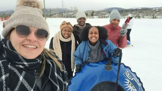 A group of five people taking a selfie photo in the snow