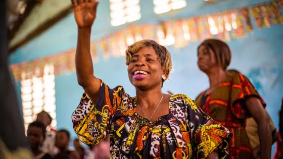 A woman with her arm raised in a church building