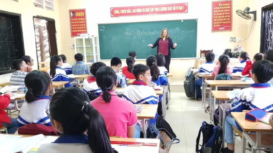 A woman teaching a class of students at desks