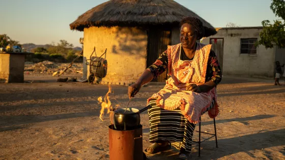 A woman cooking outside of her home in Zimbabwe