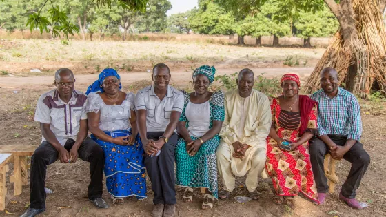 A group of seven people sitting on a bench in Nigeria