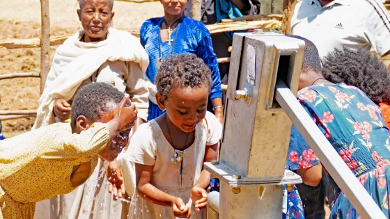 A picture of children in a community in North Achefer woreda demonstrate to visitors from MCC and partner Afro-Ethiopia Integrated Development (AEID) their excitement about having access to clean drinking water from a well built in January 2023.
