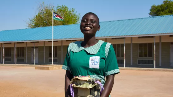 Rebecca Amok Marial, student at Saint Mary’s Primary School in South Sudan, holds her MCC school kit filled with pencils, paper and other essential items she needs to learn. 