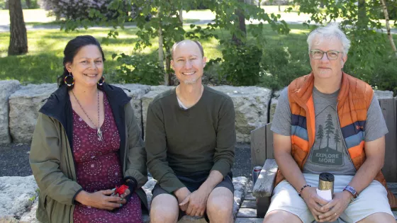 Ko’ona Saber, Kerry Saner-Harvey and Jonathan Neufeld sitting together on a bench
