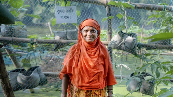 Taslima Khatun at her floating garden with plants growing in a hanging garden along the shore. She can harvest all year round and her garden is safe from floods. Project implemented by MPUS and funded by MCC. Bogura, Bangladesh.