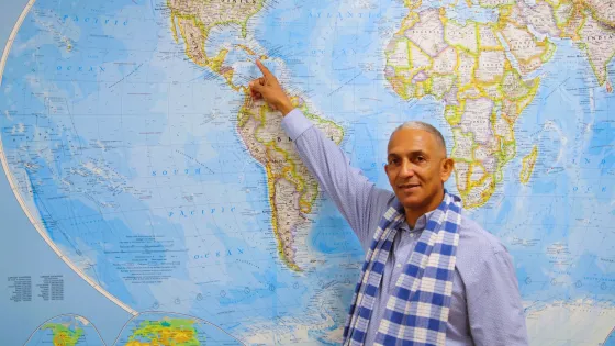 man points at Cuba on a map