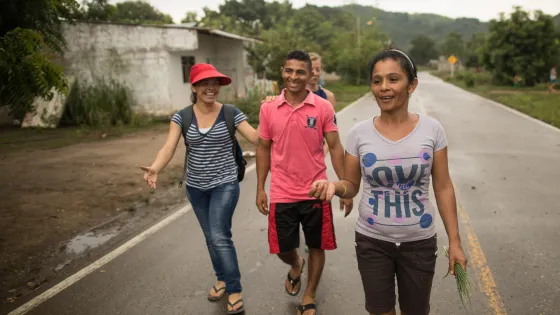 Three people walk down a road