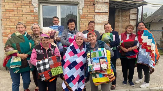 People from Ukraine’s Zaporizhzhia region display MCC comforters received during a distribution by MCC partner Association of Mennonite Brethren Churches of Ukraine. 