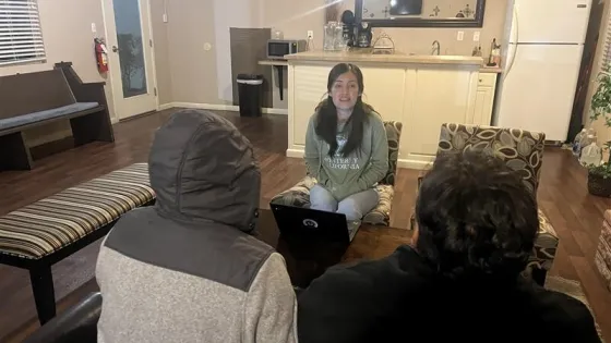 woman facing two people with backs to the camera