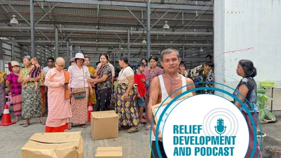 Man holding a box that says MCC, logo of relief, development and podcast