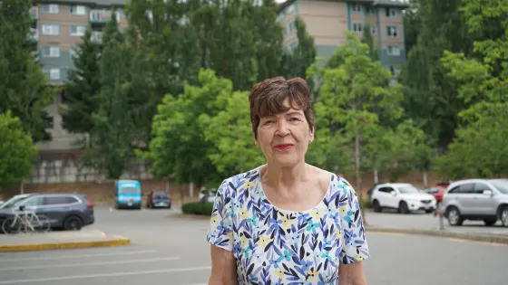 Linda Fraser stands outside in front of an apartment building, similar to the one she rents in Abbotsford, British Columbia