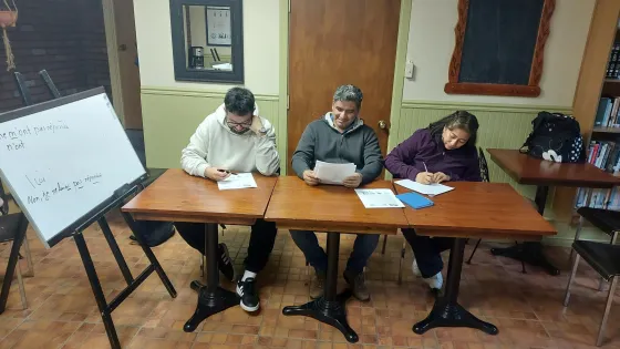 Three students write exercises in french class at sainte rose church in montreal