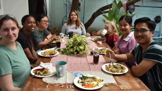 A group gathers around a table to eat