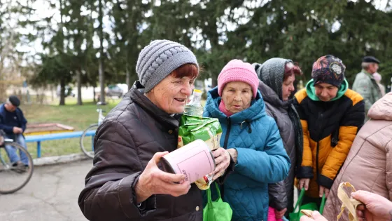 People in Ukraine stand in line to receive MCC material resources like canned meat. 