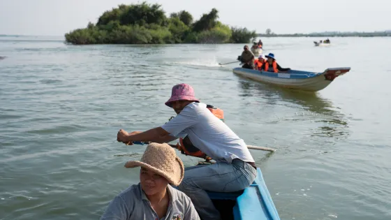 Kun Nora, 32, with Sor Navy, 36,  steers the boat on a patrol along the Mekong River as they check for illegal fishing.