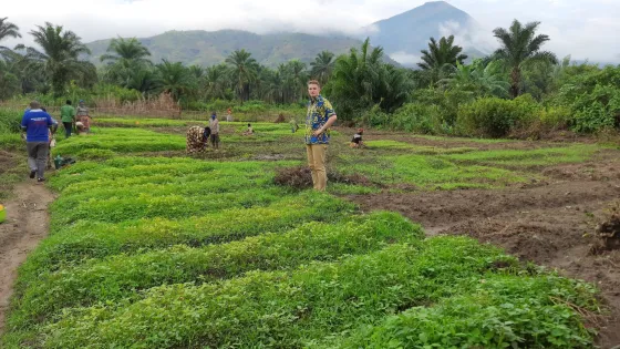 Jacob Yoder, representative for the Democratic Republic of the Congo, stands in a field during a visit to partner organization Oasis de la Culture in fall 2021.