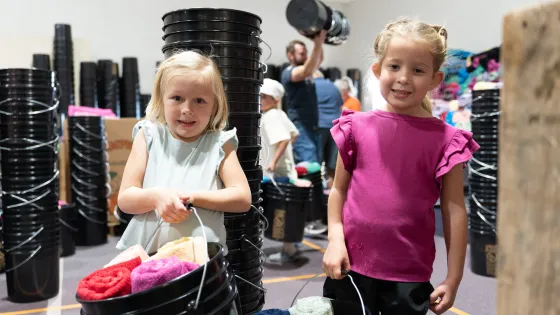 Hazley Cillers and Riley Miller, both 5 years old, carry buckets filled with essential hygiene items during Pleasant View Mennonite Church's fourth annual relief kit packing event.