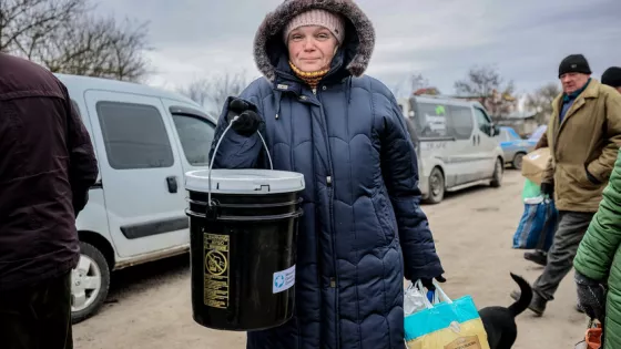 A woman* in a village recovered from Russian military control in Ukraine's Kherson region displays the MCC relief kit she received from MCC partner Charitable Foundation Uman Help Center (Uman Help Ce