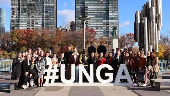 Participants pose in front of a sign at the United Nations Headquarters during the MCC UN Student Seminar in New York City in November 2025.