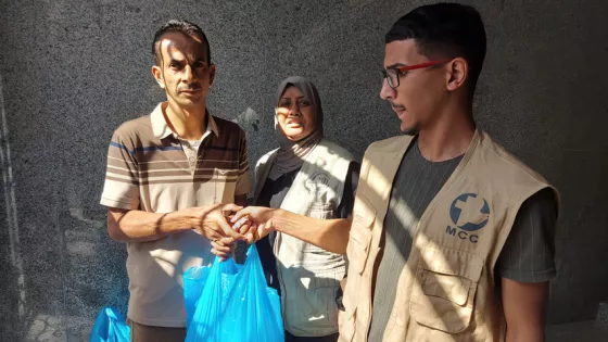 On October 17, 2023, Firas Hamlawi, right, a volunteer and Rifqah Hamlawi, center, a staff member, with  Al-Najd Developmental Forum, helped distribute food packages to 35 families and bedding to 10 f